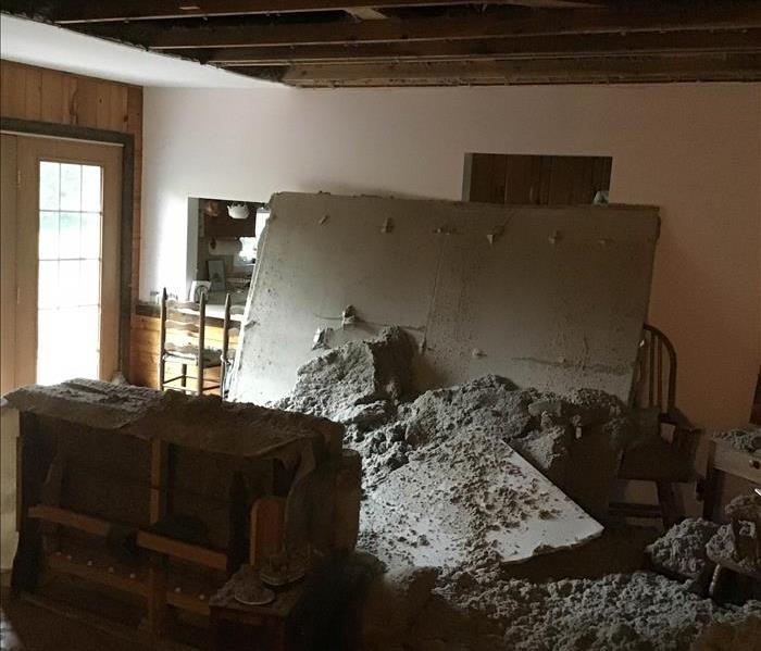ceiling collapsed with debris covering a living room