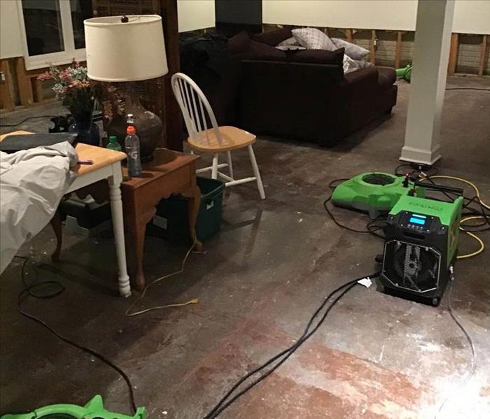 living room floors are gone while air movers attempt to dry the space 