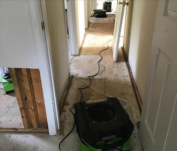 Air movers placed in the hallway of a home, flooring removed